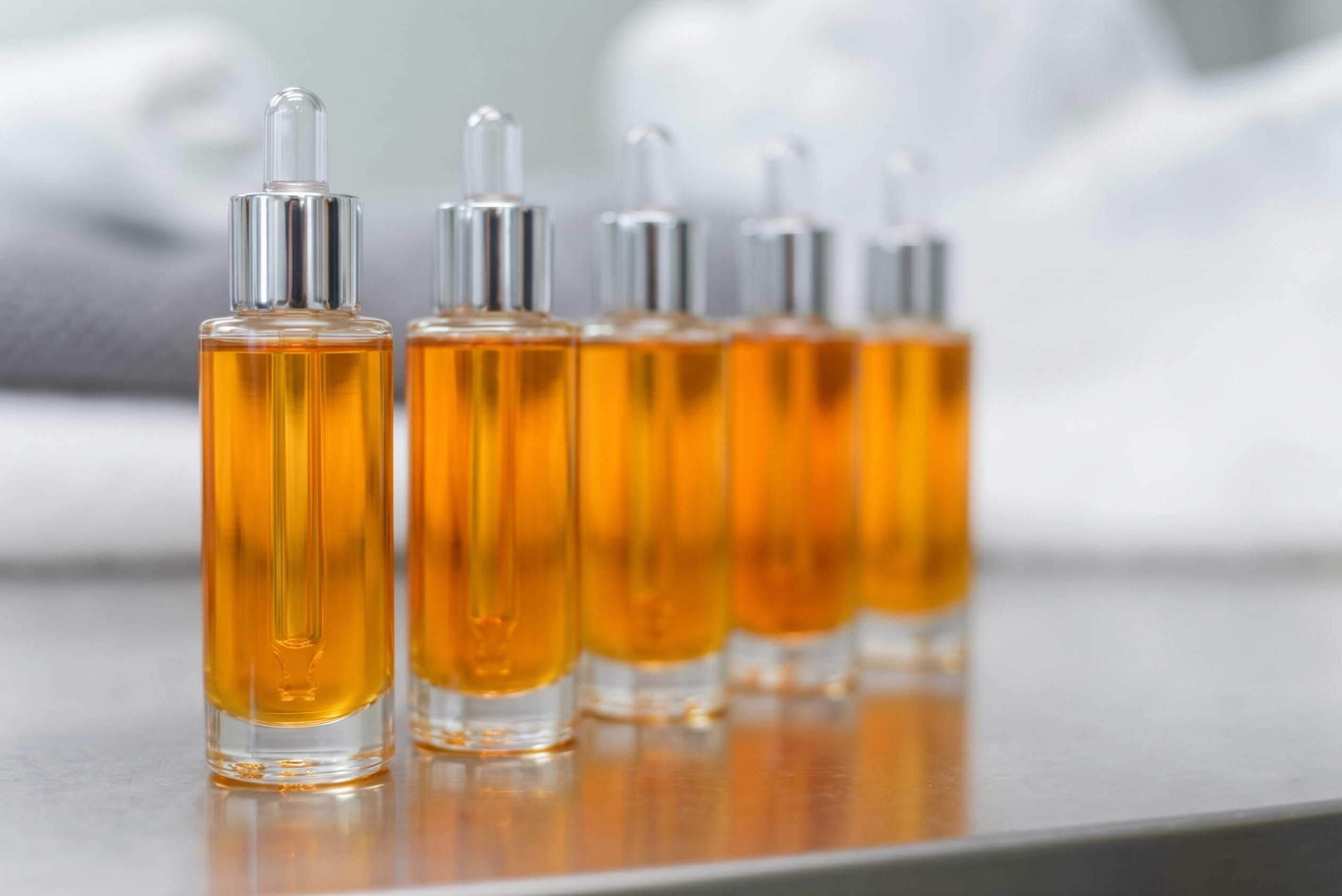Pipettes d’huile parfumée alignées sur un plan de travail